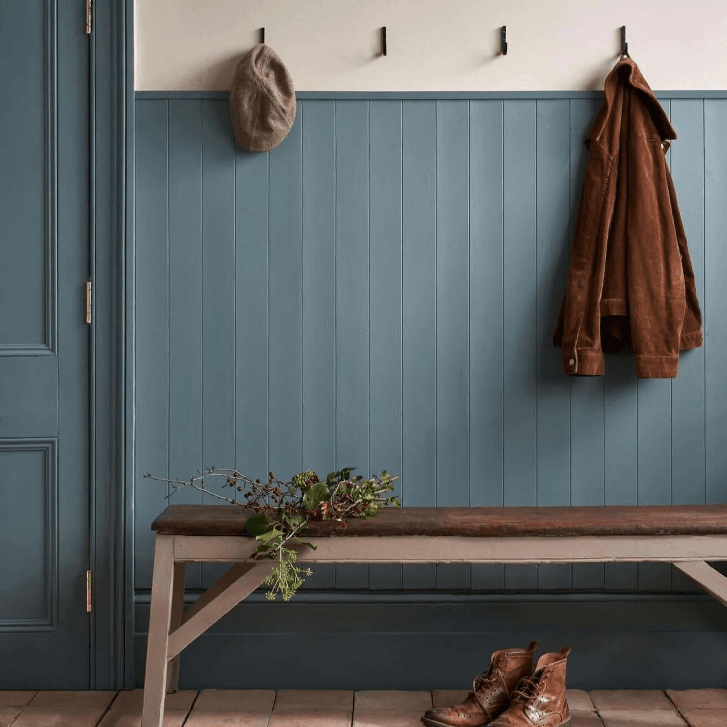 Cambrian Blue - Annie Sloan Satin Paint used on wall with hooks, bench, hat, and jacket in a stylish boot room.