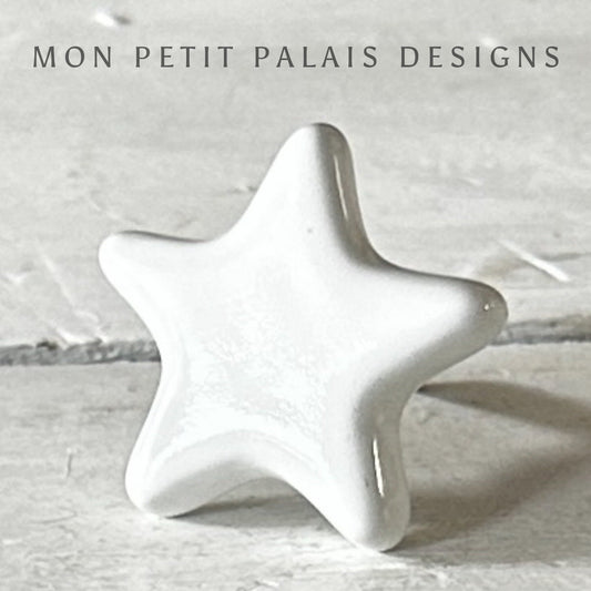 White ceramic star-shaped knob with metal screw,