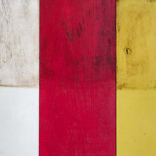 Annie Sloan Dark Chalk Paint in vibrant red, white, and yellow hues on wooden surface for furniture and décor.