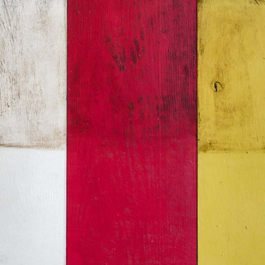 Annie Sloan Dark Chalk Paint in vibrant red, white, and yellow hues on wooden surface for furniture and décor.