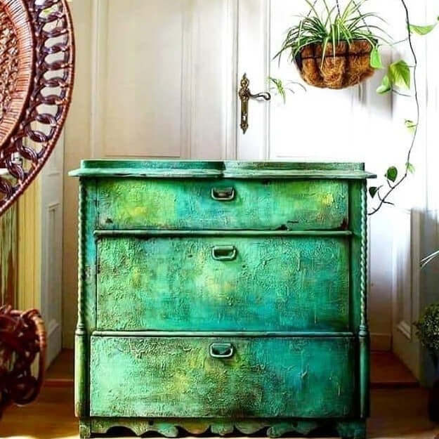 Rustic chest of drawers in layered green chalk paint with an aged patina effect using Annie Sloan Antibes Green.