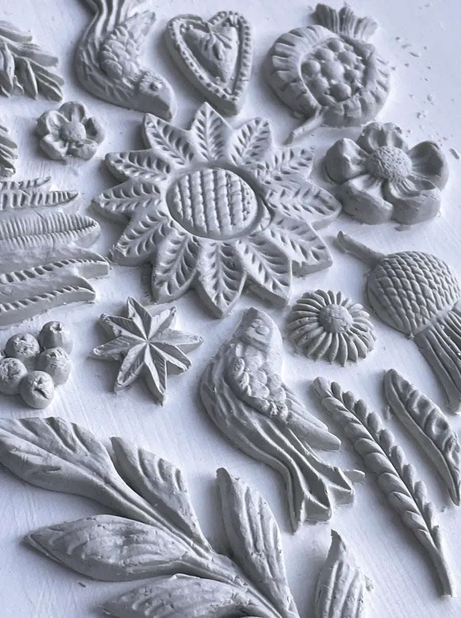 IOD Primitive Decor Mould showcasing intricate designs of flowers, birds, and rustic motifs for home décor.