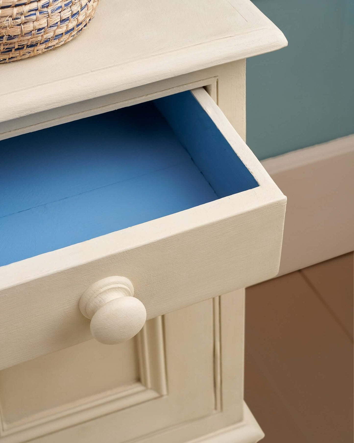 Detail of open drawer painted in Canvas with a surprise pop of bright blue inside.