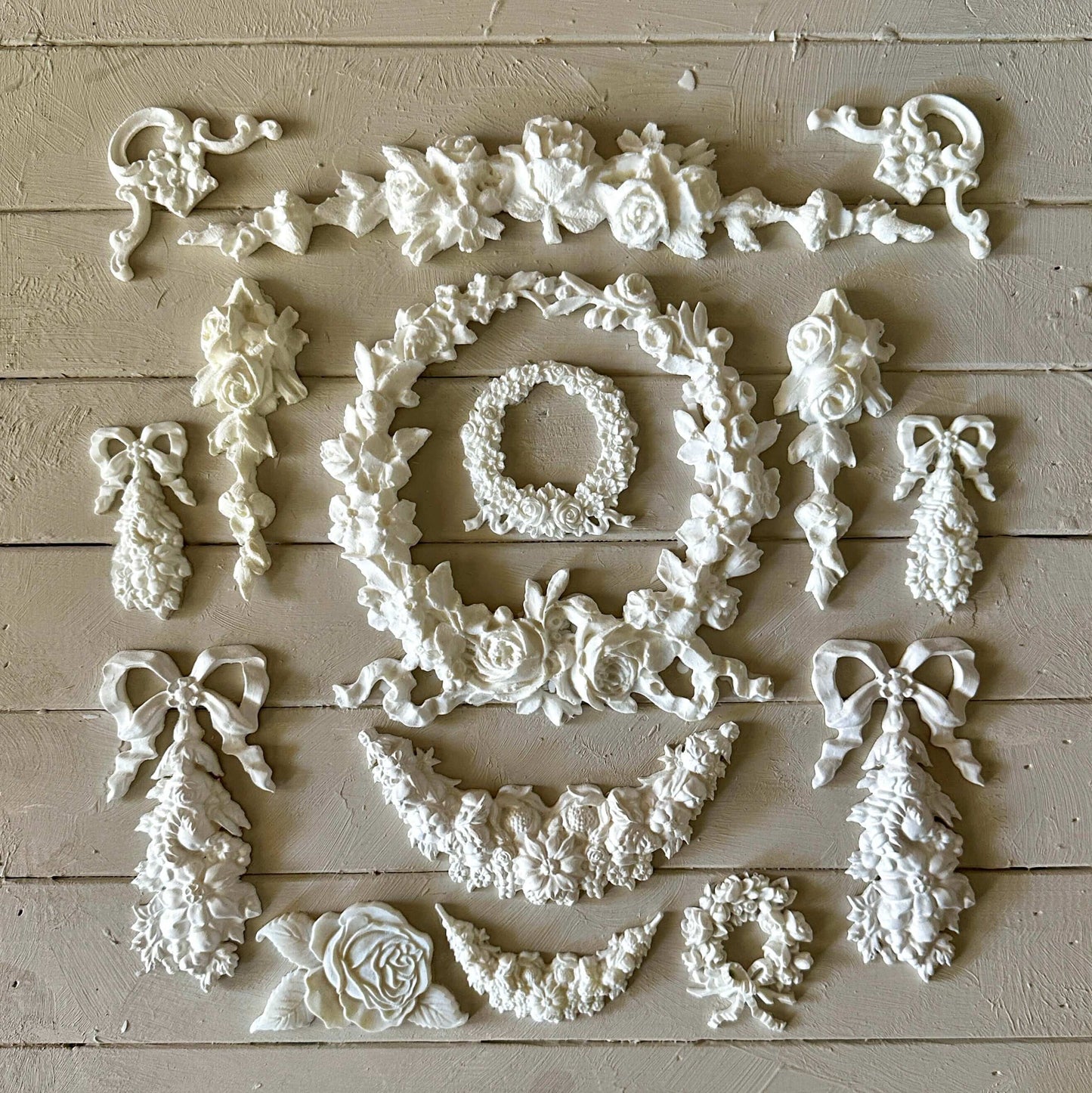 Swag 003 - Resin Applique for Furniture & Crafts arranged in a beautiful floral design on a light wooden surface.