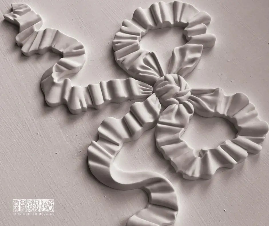 Close-up of IOD Bows Decor Mould showcasing intricate ribbon designs for DIY projects.
