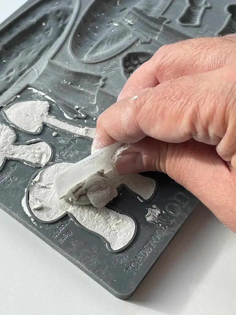 Person using the IOD Toadstool Decor Mould to create textured mushroom designs from clay.