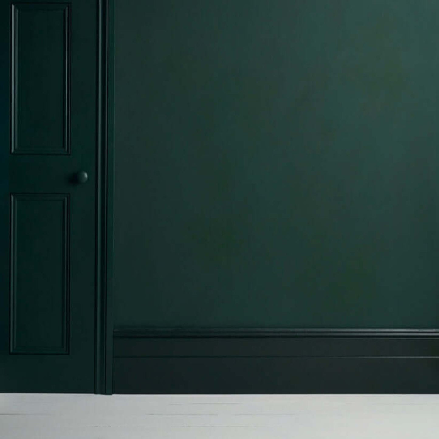Knightsbridge Green - Annie Sloan Satin Paint on a wall with a door, showcasing a rich forest green color.