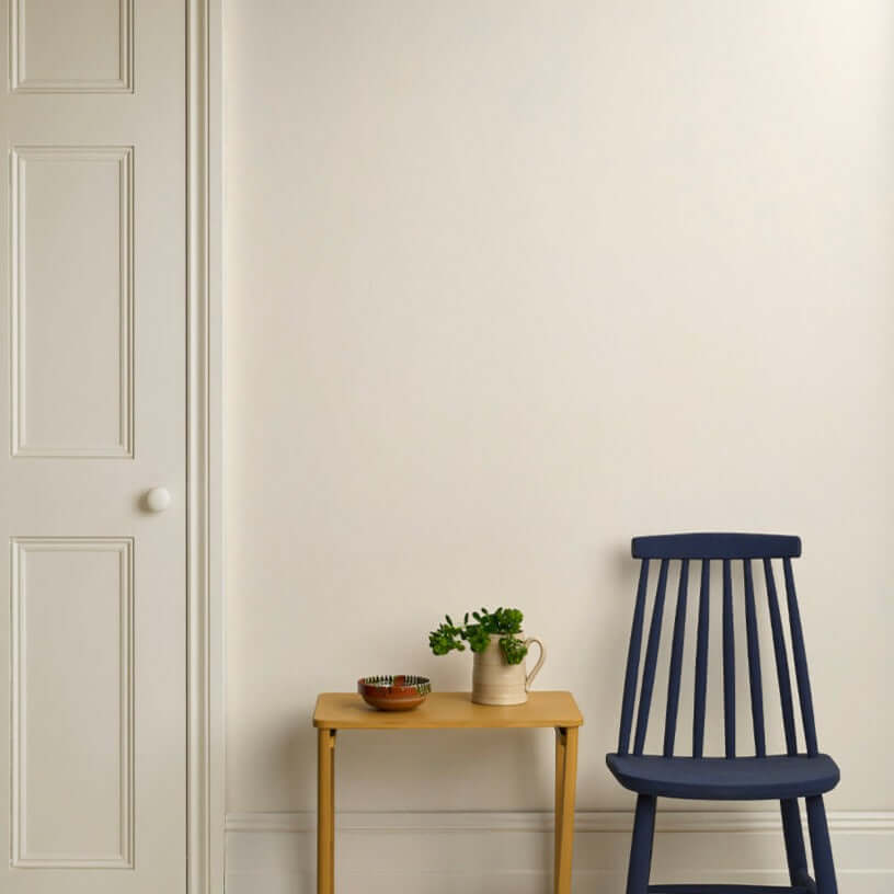 Original - Annie Sloan Satin Paint used on a wall with a blue chair and wooden table.