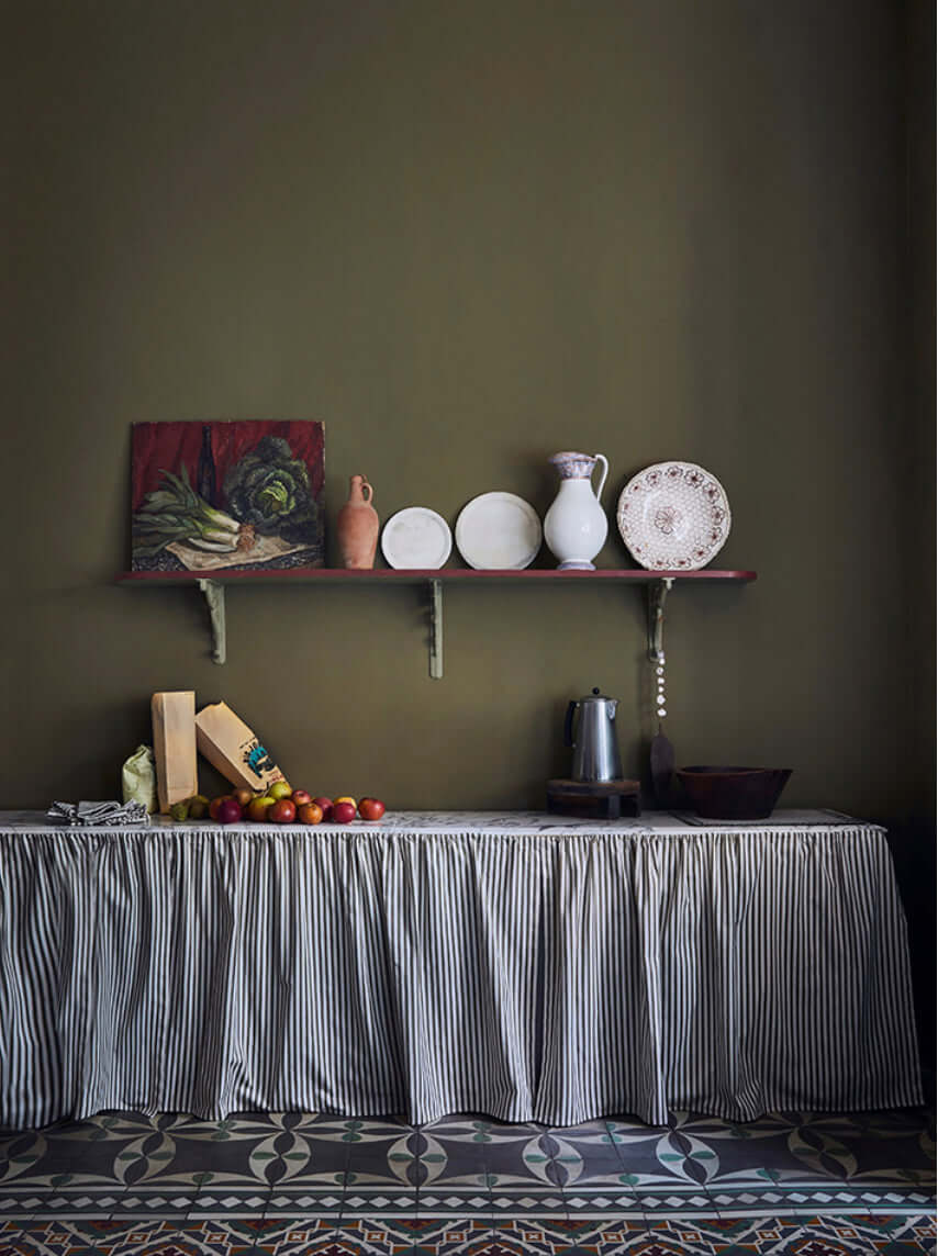Serene kitchen scene featuring Olive Annie Sloan Wall Paint®, with a rustic table and decorative items.