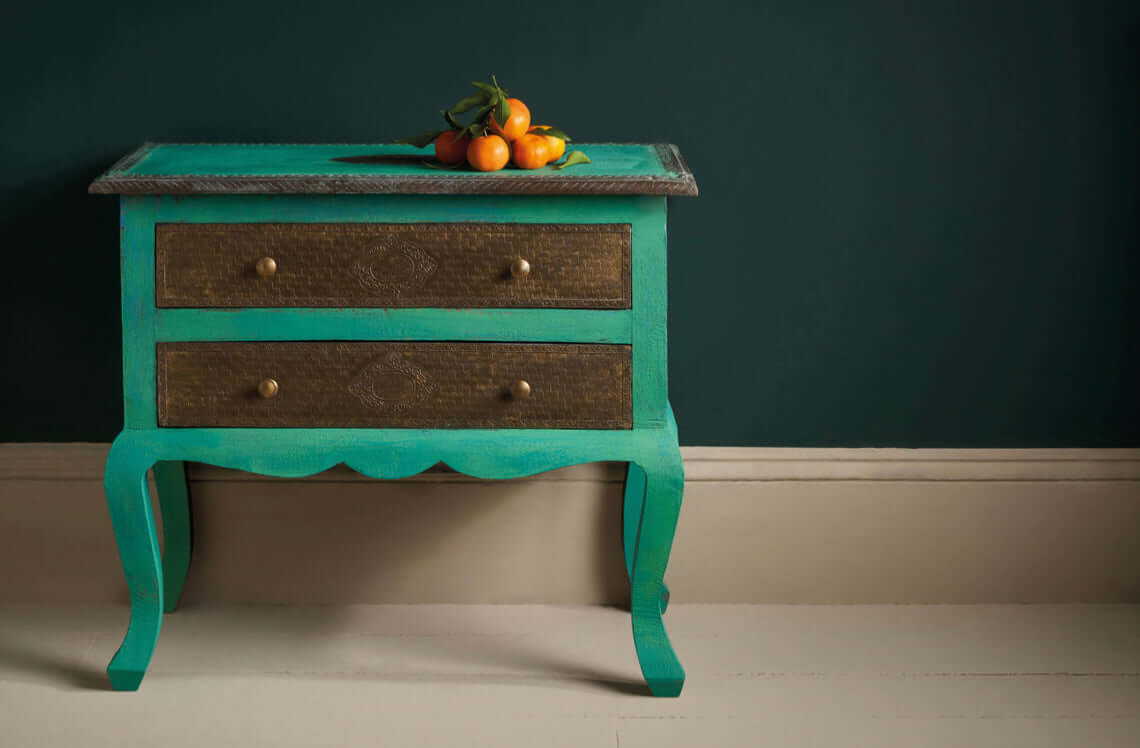 Knightsbridge Green - Annie Sloan Wall Paint used on a stylish blue-green vintage bedside table with fresh fruit on top.