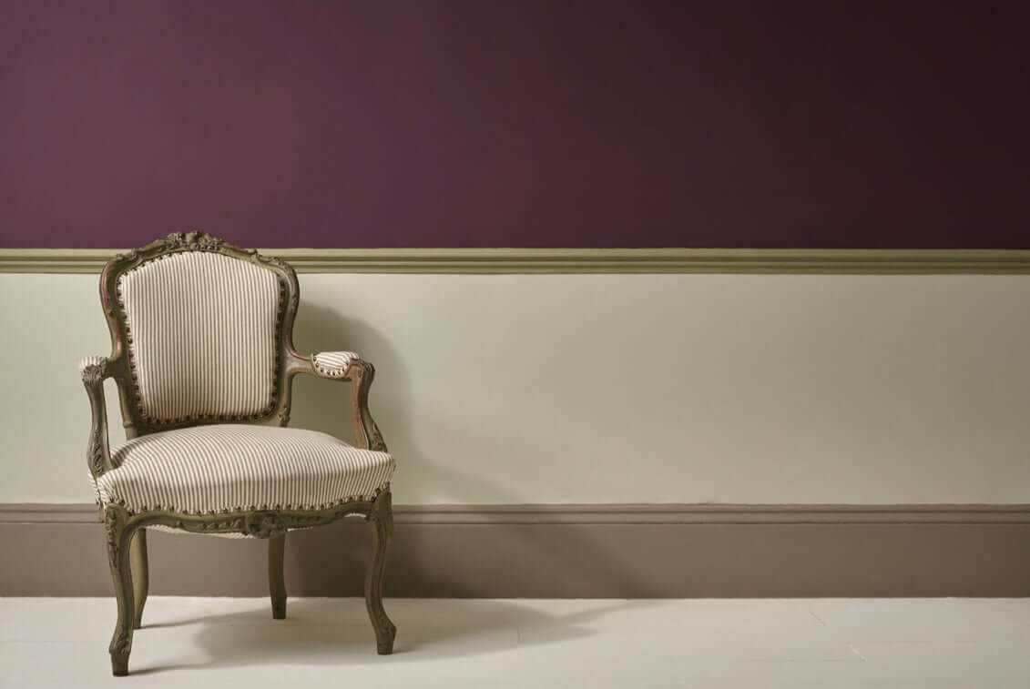 Elegant chair against a wall painted in Tyrian Plum - Annie Sloan Wall Paint, showcasing rich color contrast.