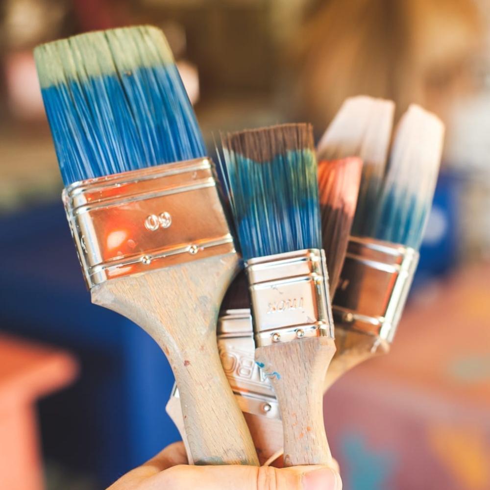 Set of Annie Sloan paint brushes including small wall, flat, and detail brushes with blue synthetic bristles and ergonomic wooden handles for chalk paint applications