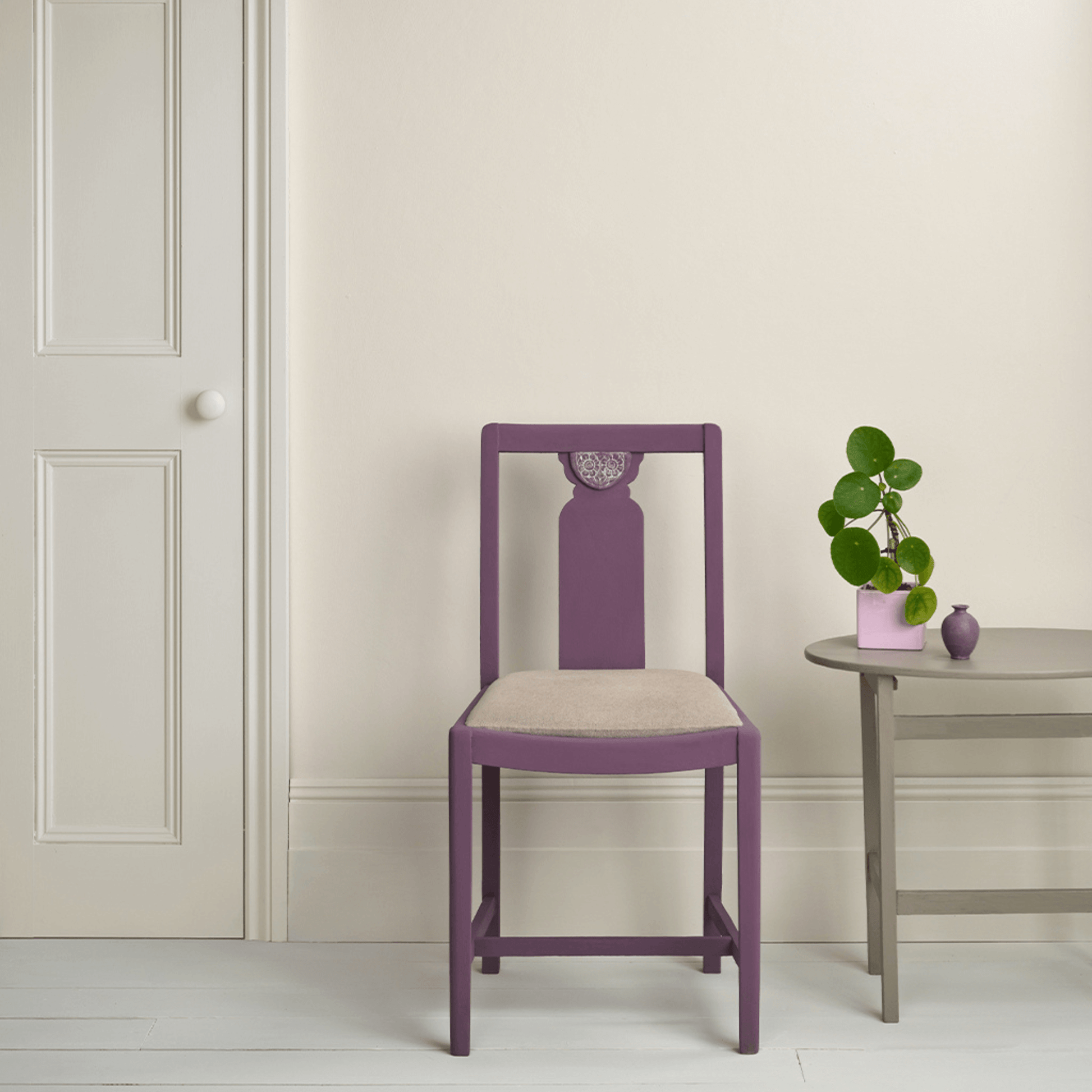 Old White - Annie Sloan Satin Paint used on walls with a purple chair and a potted plant in a stylish interior.