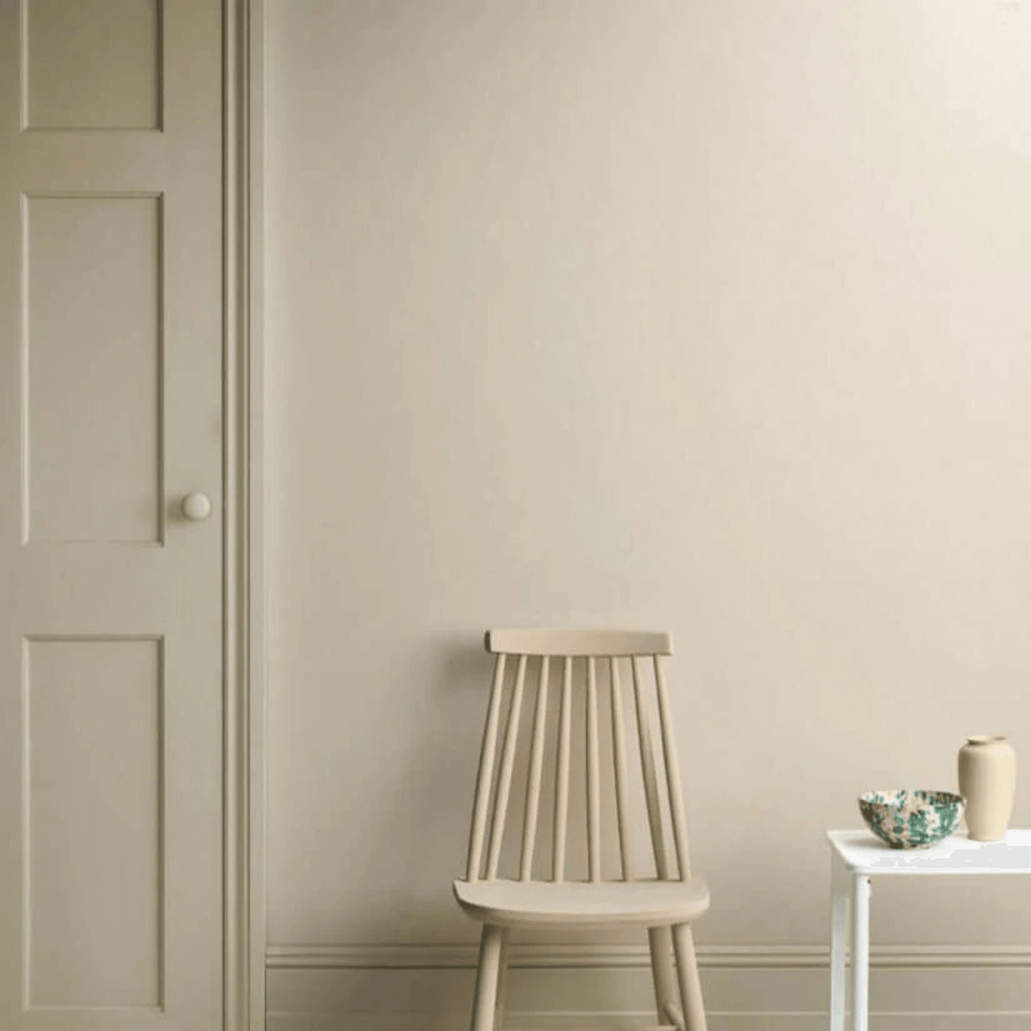 Canvas - Annie Sloan Satin Paint displayed on a wall with a chair and side table.
