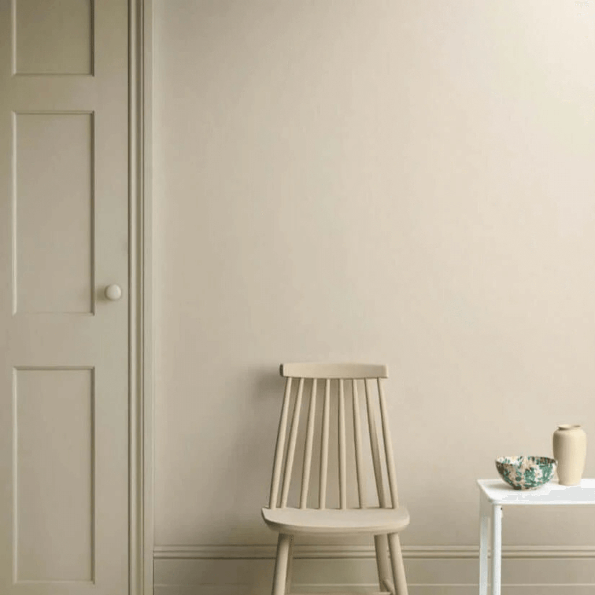Canvas - Annie Sloan Satin Paint displayed on a wall with a chair and side table.