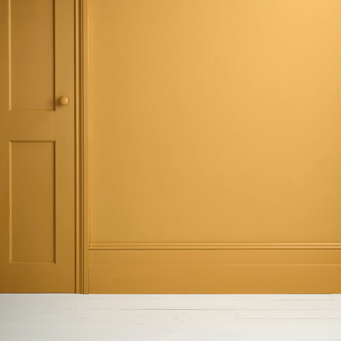 Carnaby Yellow - Annie Sloan Satin Paint on a wall and door, showcasing a rich mustard yellow color.
