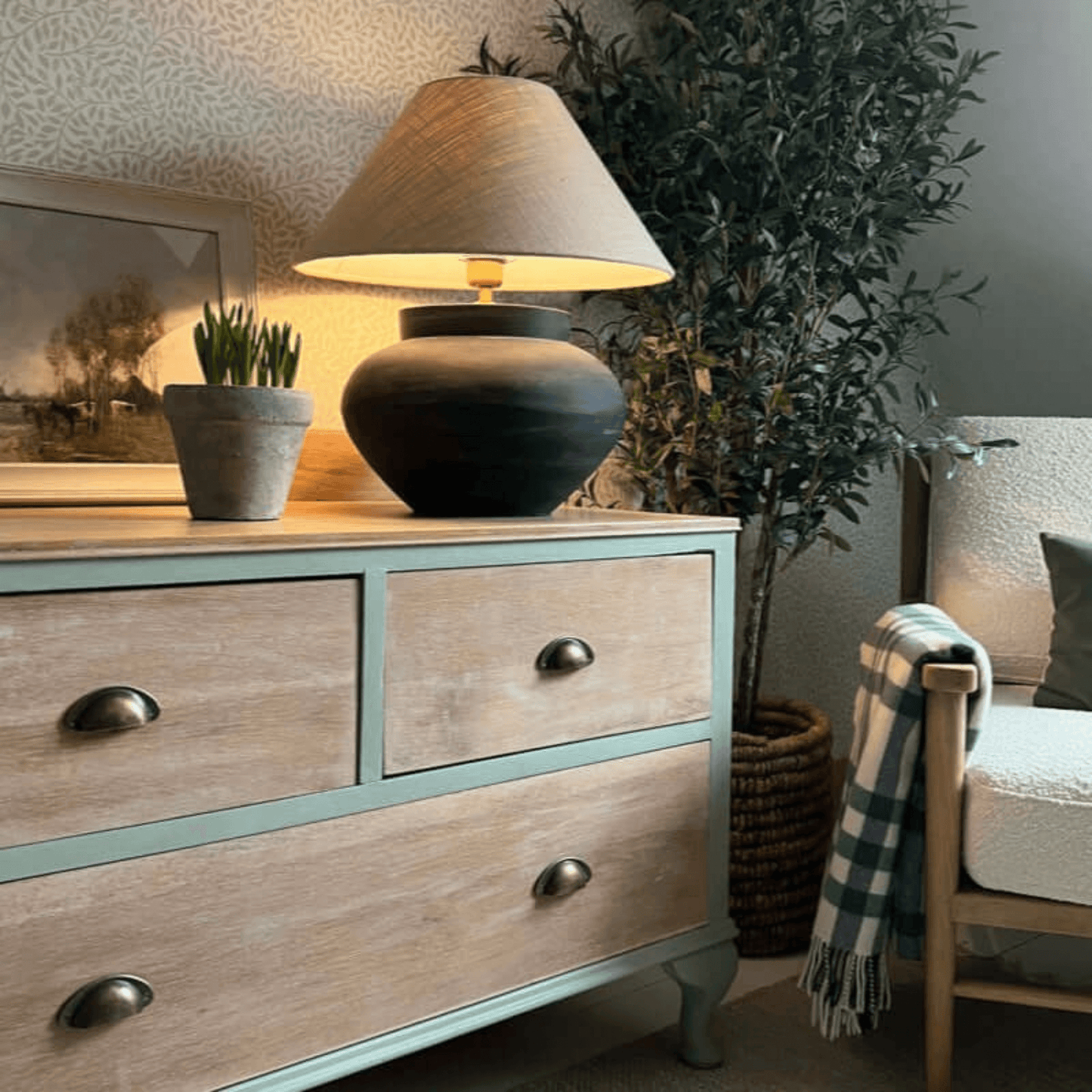 Interior design featuring Coolabah Green Annie Sloan Chalk Paint® on a dresser with a lamp and plants.