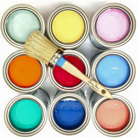 Annie Sloan 101 Chalk Paint Workshop supplies featuring vibrant chalk paint colors and a brush.