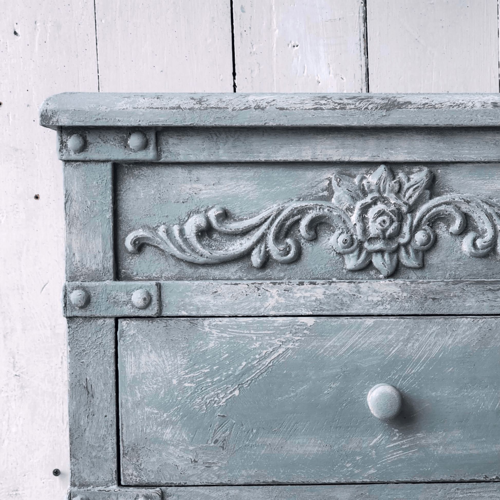 Decorative wooden cabinet with floral carvings on a white background
