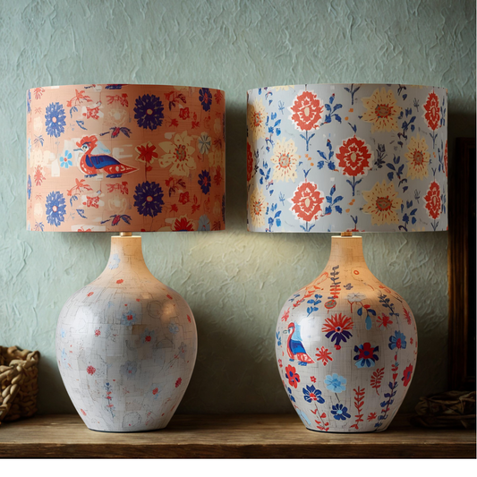 Two floral-patterned lamps on a wooden surface with a green wall background.