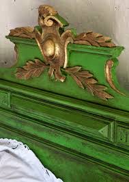 Annie Sloan Dark Chalk Paint™ Wax used on a vintage green painted furniture headboard with gold embellishments.