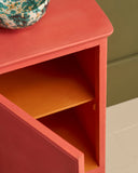 Close-up of cabinet painted in Sandalwood Red with open door showing painted interior shelf.