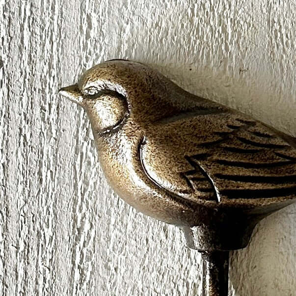 Bronze Bird Wall Hook showcasing detailed wings and a warm metallic finish against a textured wall.