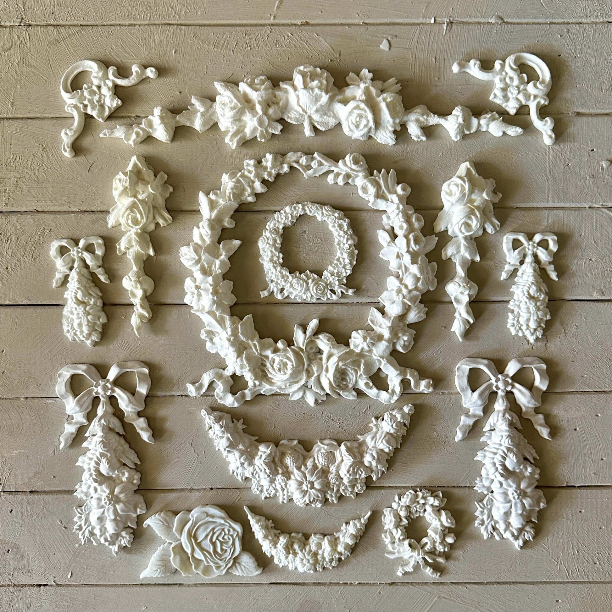 Swag 003 - Resin Applique for Furniture & Crafts arranged in a beautiful floral design on a light wooden surface.