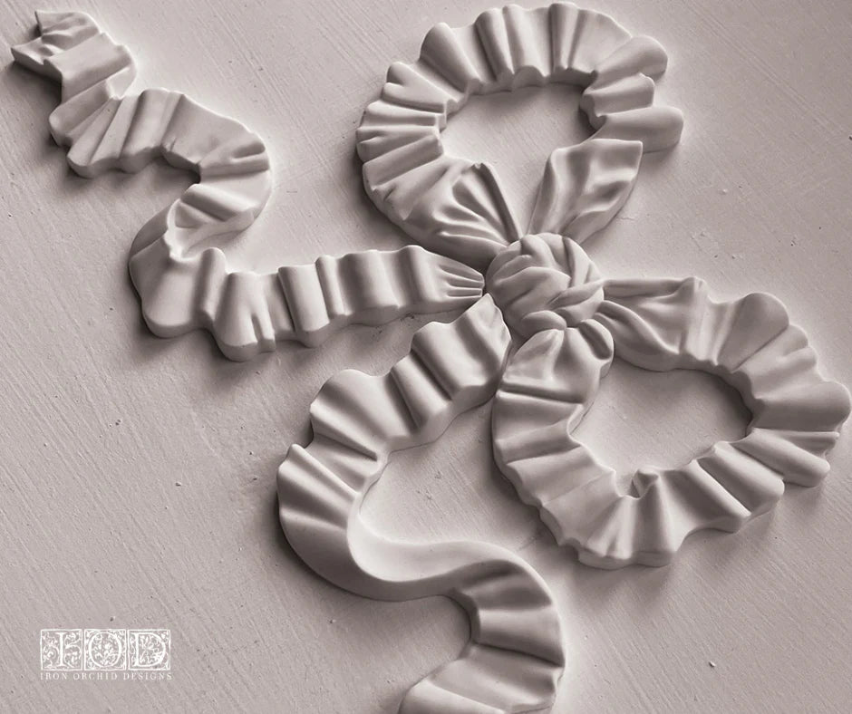 Finished casting from the Bows IOD Décor Mould featuring a beautifully detailed bow with flowing ribbon details, ideal for adding timeless charm to furniture, decor, or wall art projects.