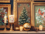 A cozy holiday display featuring framed vintage Christmas art with a tree and cardinals, alongside festive candles and gold ornaments, created with IOD Yuletide Decor Transfers.