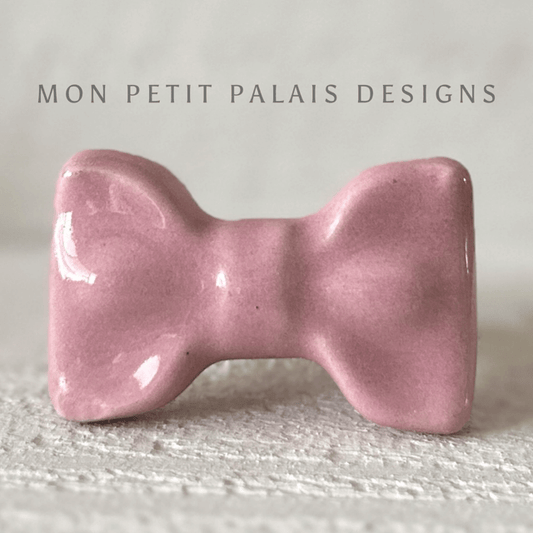 Pink Ceramic Bow Cabinet Knob showcasing chic bow design and glossy pink finish.