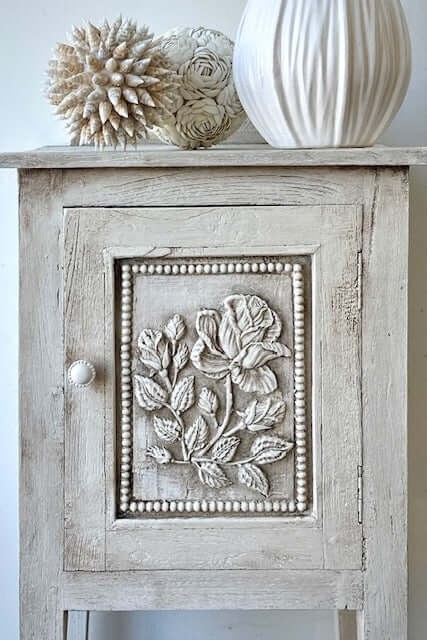 Wildflower cabinet close up of floral detailing hand painted with Annie Sloan Chalk Paint in Old White with dark wax accents.