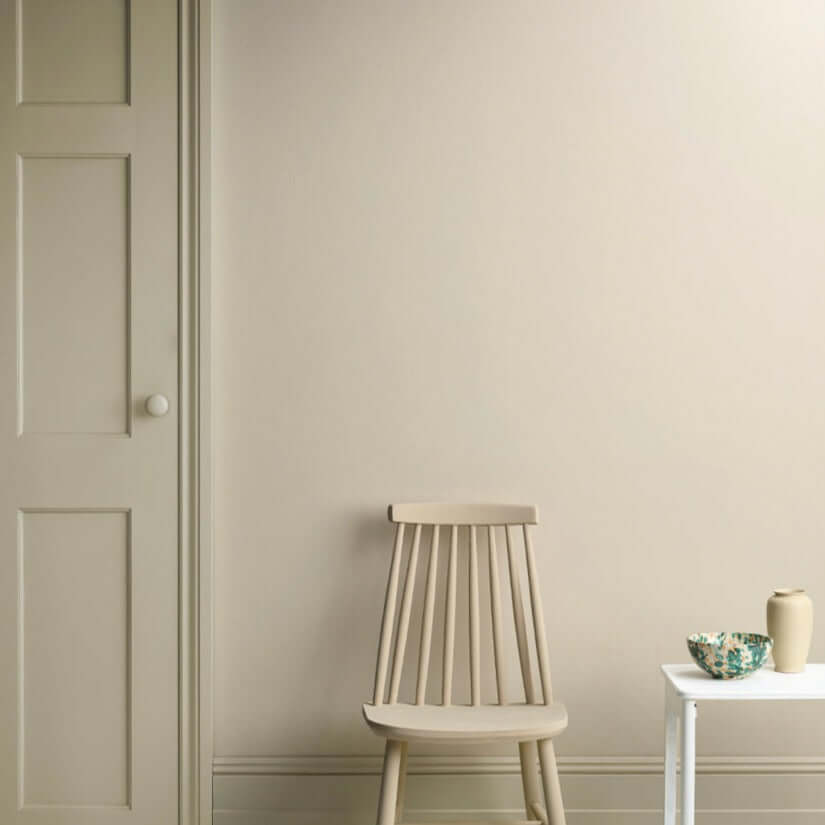 Canvas - Annie Sloan Satin Paint displayed on a wall with a chair and side table.
