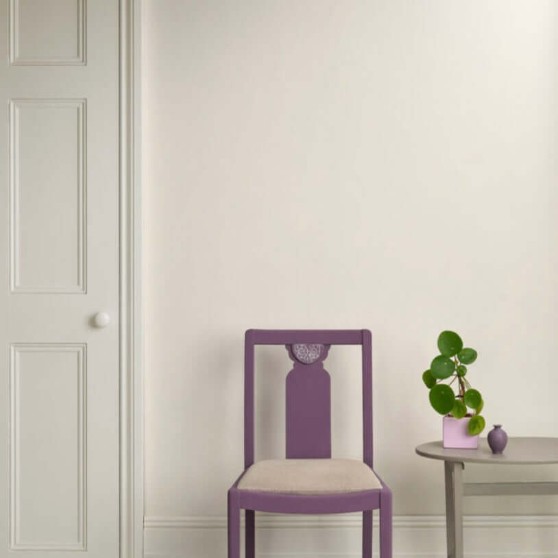 Old White - Annie Sloan Satin Paint used on walls with a purple chair and a potted plant in a stylish interior.